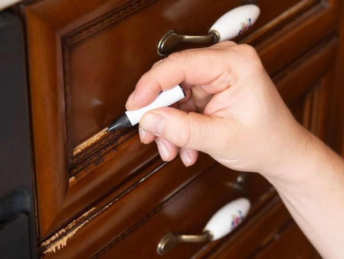 Mistrz naprawia zadrapanie na fasadzie mebla