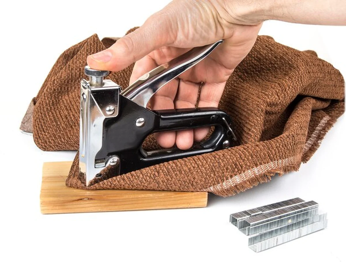 Człowiek zszywający tekstylia na białym tle