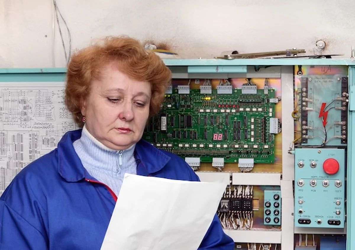 Operator kobieta-inżynier w maszynowni obok szafki elektronicznej