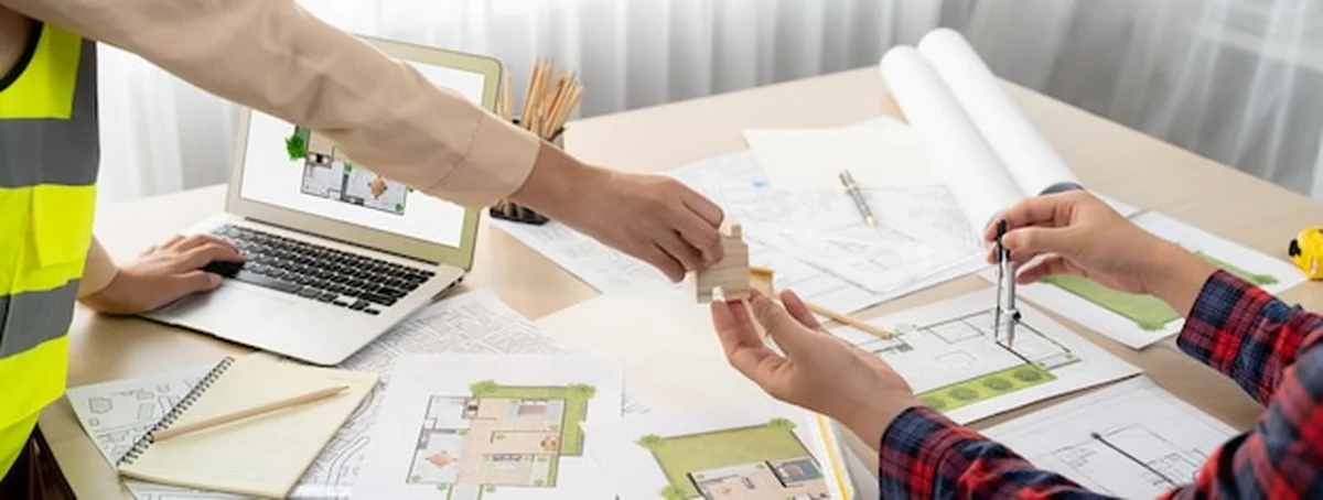 Profesjonalny inżynier i architekt przy stole konferencyjnym z projektem domu ekologicznego