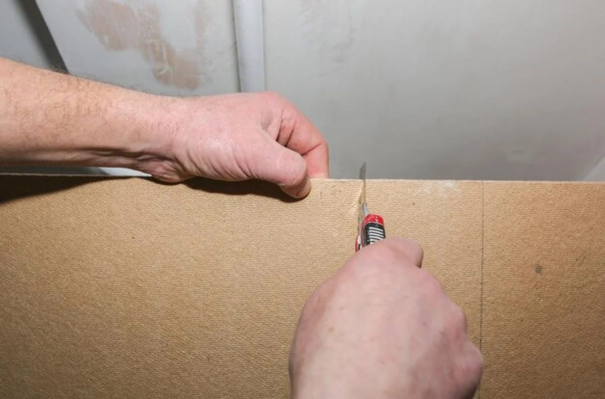 Pracownik tnie podłoże do podłóg laminowanych w mieszkaniu