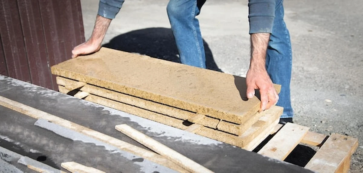 Pracownik budowlany trzymający płytkę do budowy domu