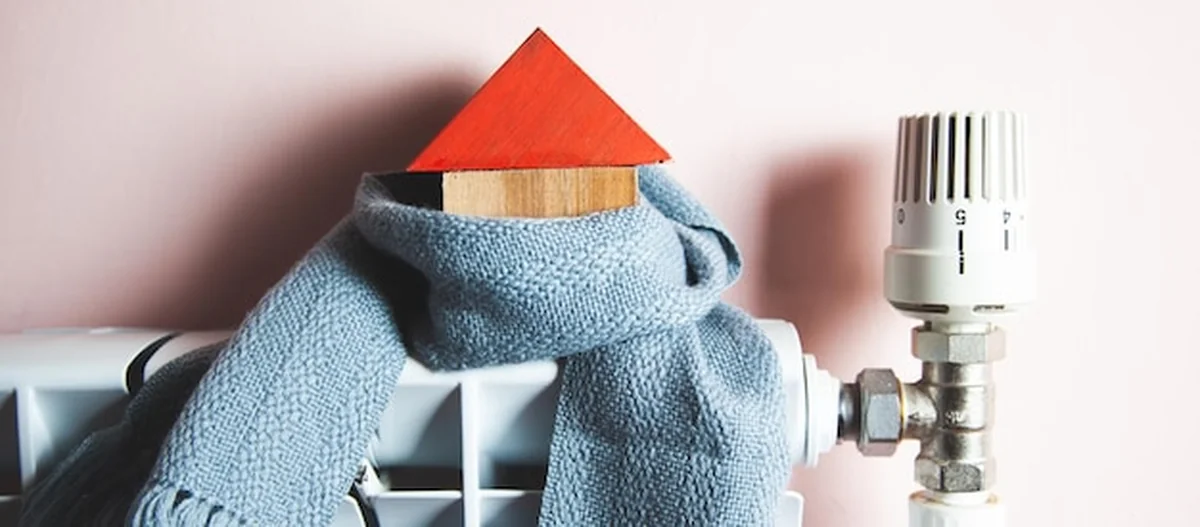 Model domu w szaliku na kaloryferze w pomieszczeniu