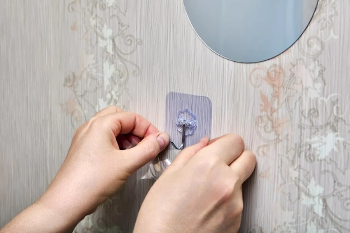 Osoba mocuje przezroczystą plasterkę na lustrze